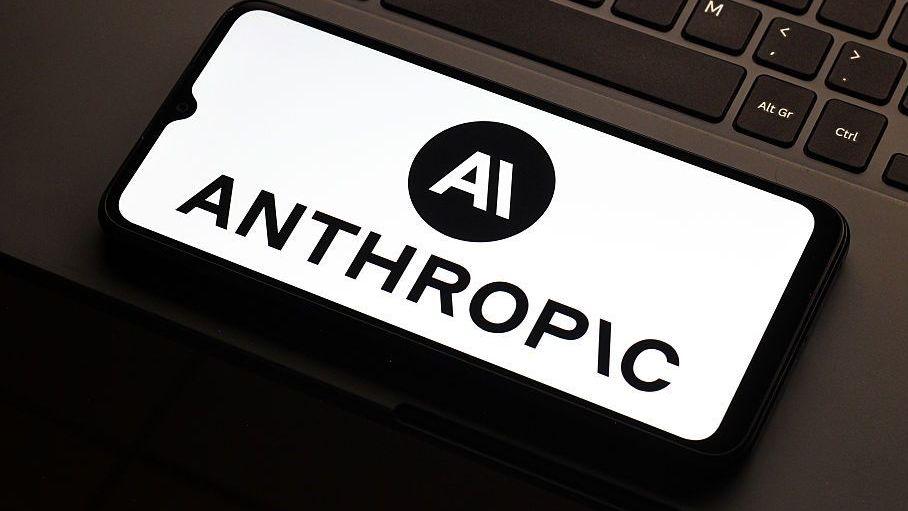Anthropic logo on a smartphone lying on a laptop mousepad