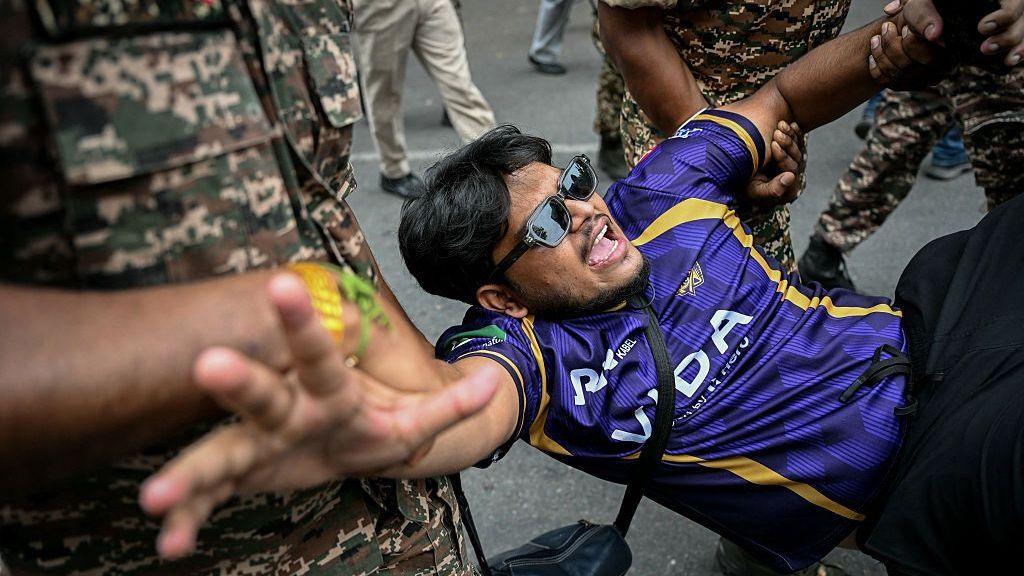 Security personnel detain a demonstrator during a protest in Delhi on 11 Oct 2026