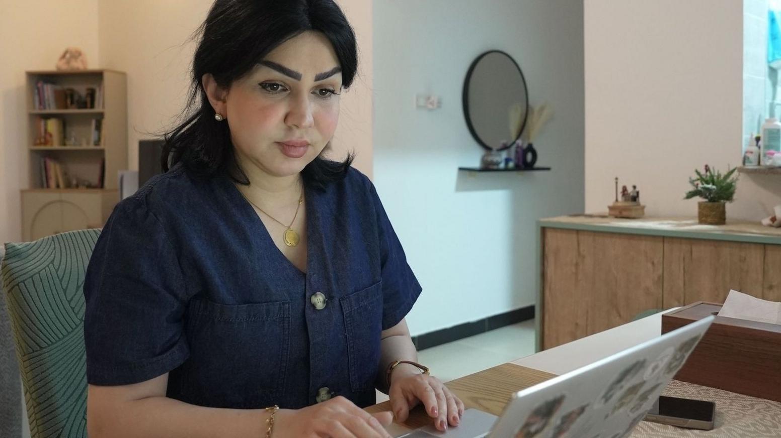 Sarah Jassim sitting at a desk