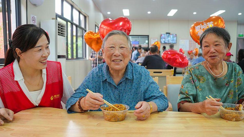Elderly residents taste longevity noodles at a community centre in Huzhou, Zhejiang, China, 2026