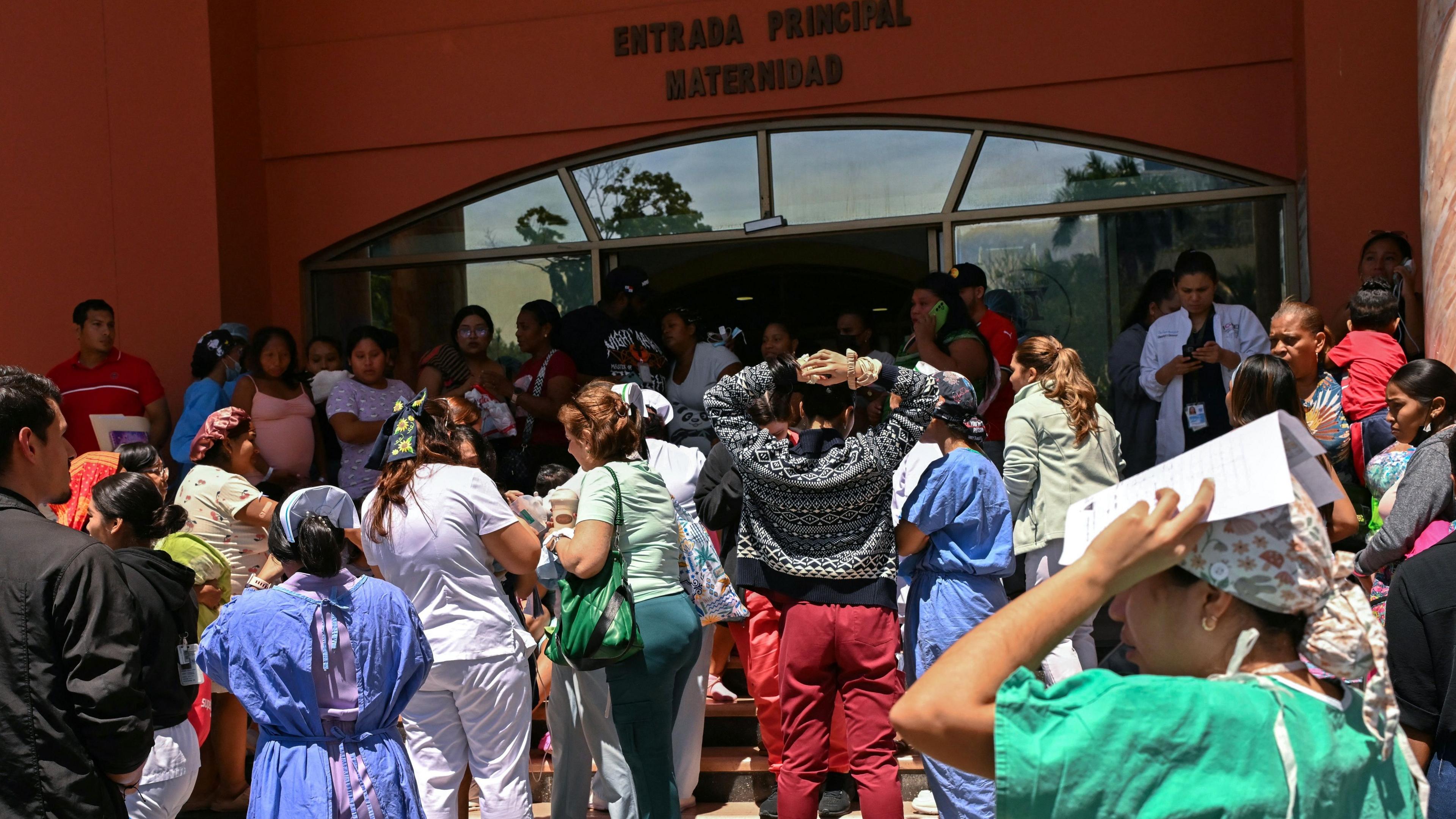 People stand outside the maternity ward of the Santo Tomas hospital after the quake