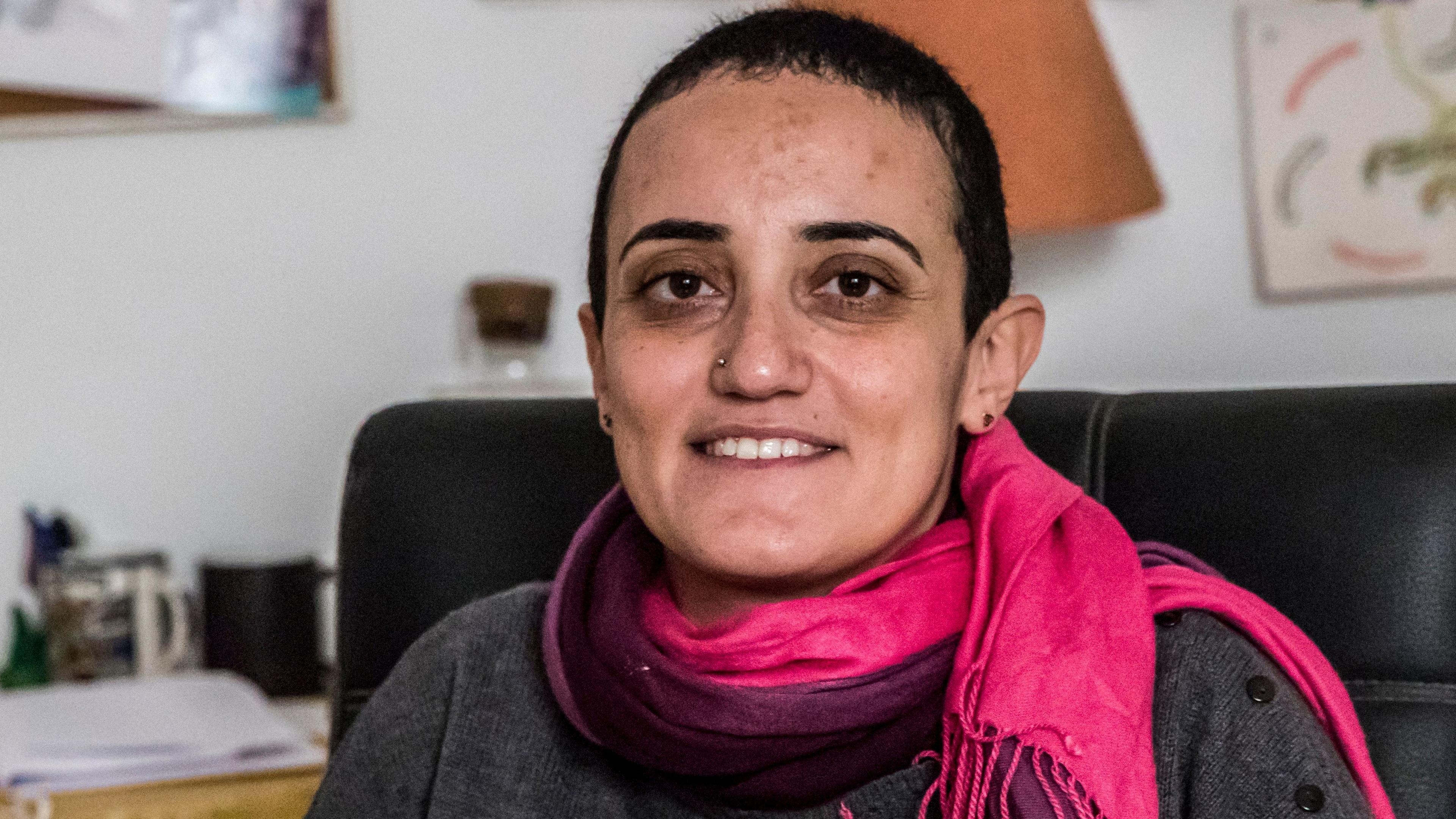 Egyptian journalist Lina Attalah sits on a black leather chair.